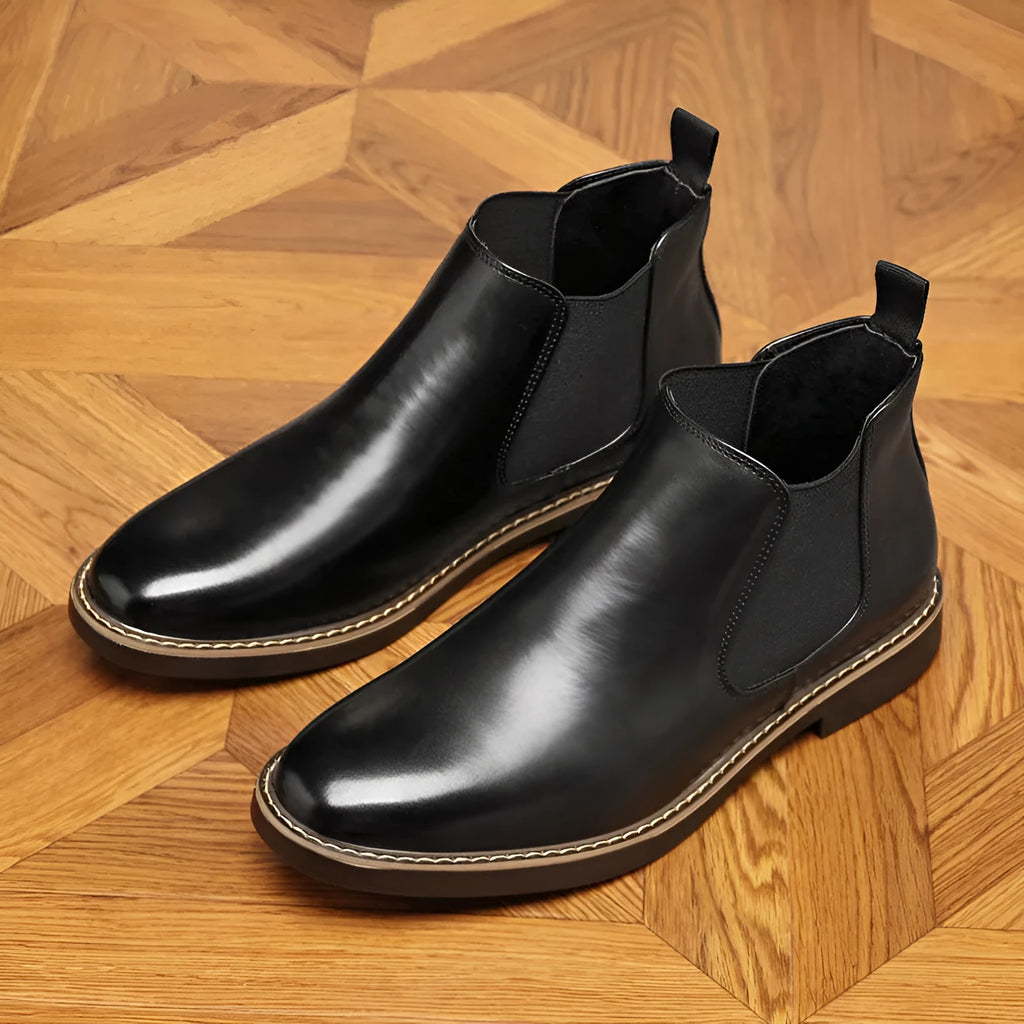 Black formal leather pointed-toe boots with a square heel and rubber sole on a white background.