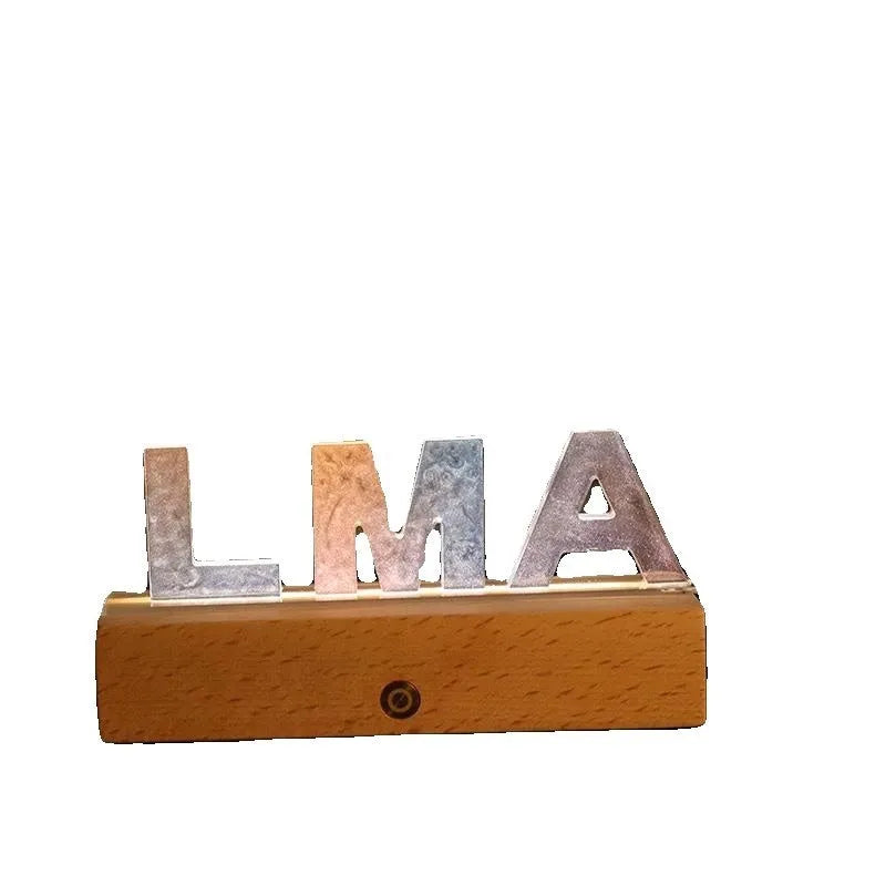 Letter small night lamp with dried flowers, blue colour, warm light, on a table