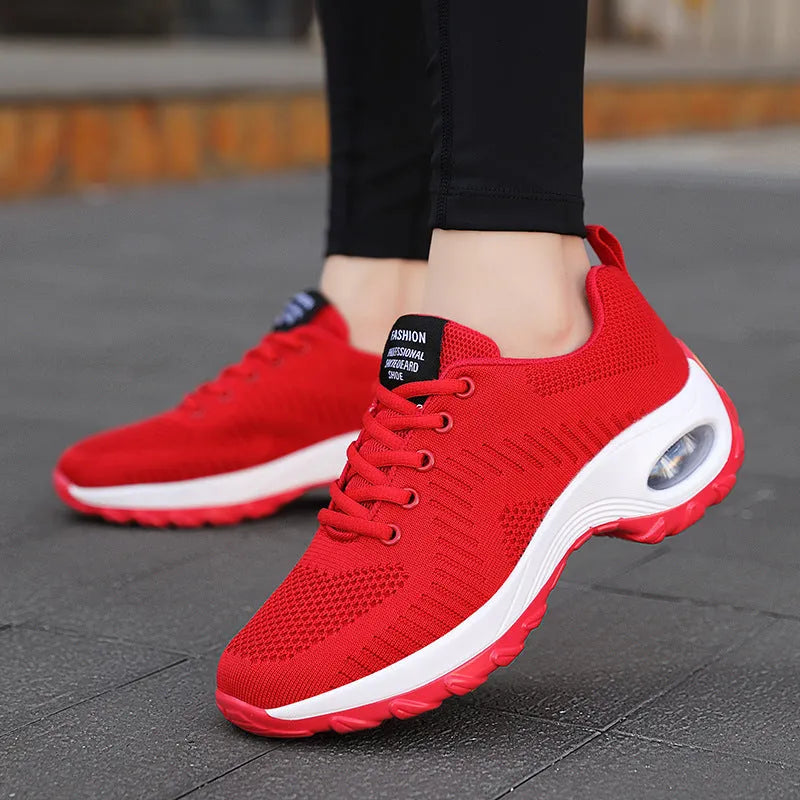 Women's round toe red and black mesh sneakers with front laces on a flat heel and textured PU sole.