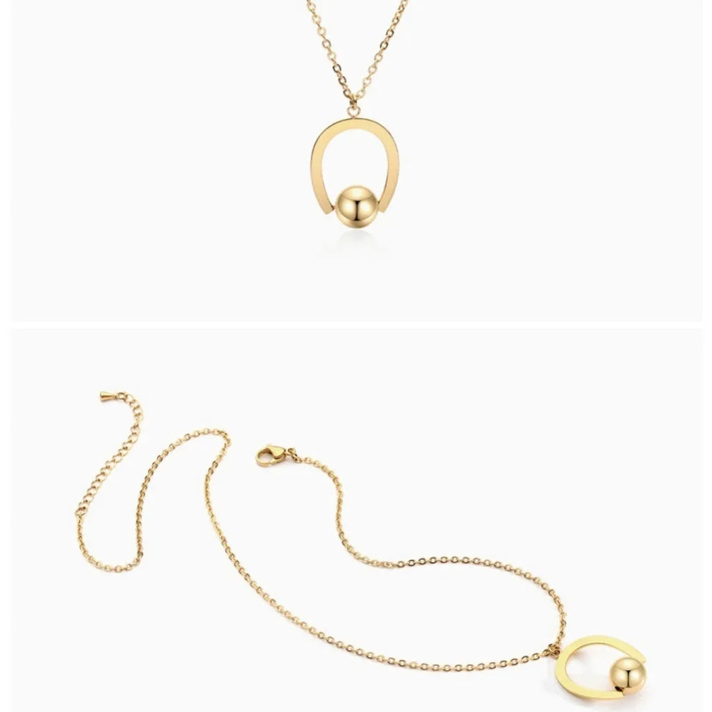 Gold tone stainless steel necklace with geometric pendant on a cross chain, shown adjusted to a medium length.