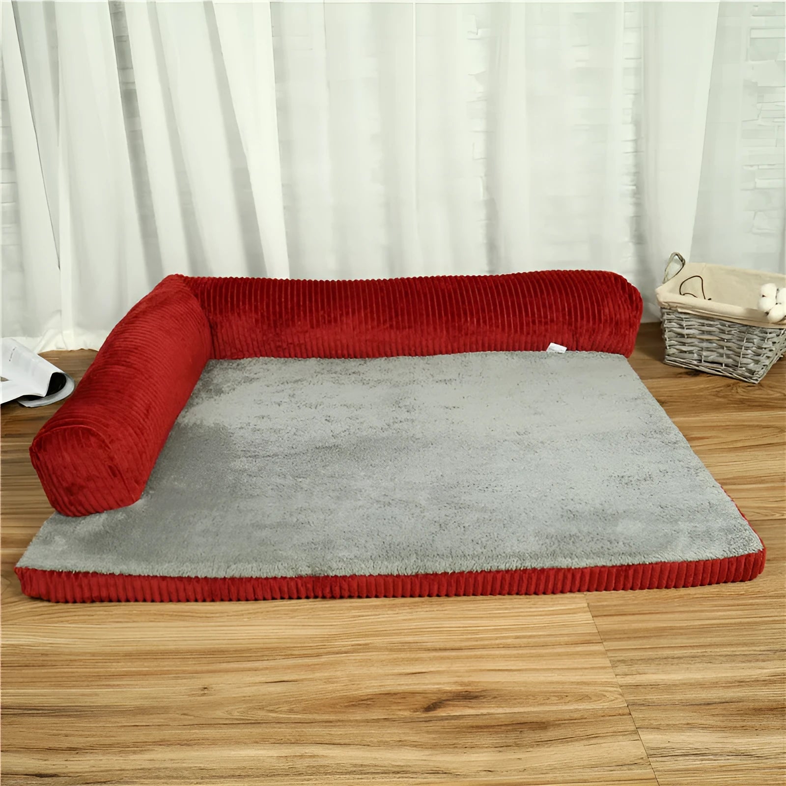 A grey corduroy bilateral-style dog sofa bed on a wooden floor