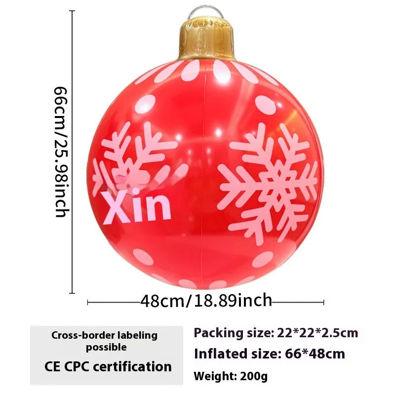 Large red and white inflatable Christmas ball with flashing lights in a garden setting
