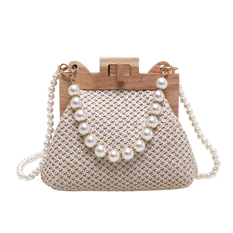 Women's woven straw shoulder bag with pearl chain detail showing horizontal square shape and multiple internal pockets
