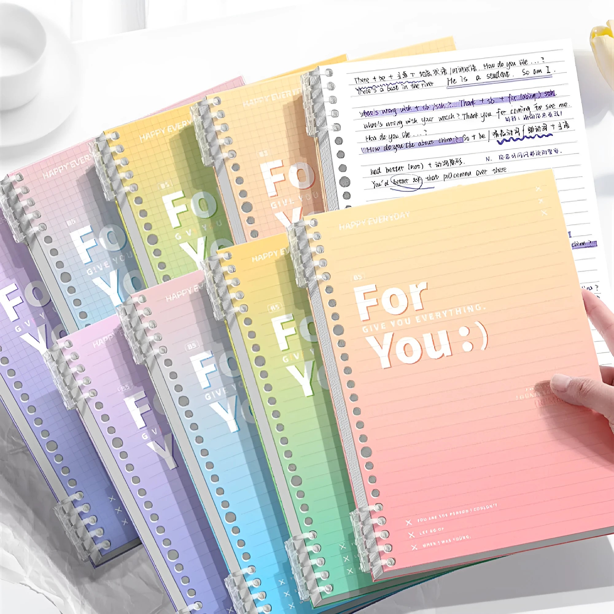 A gradient-coloured removable coil notebook in A4 size with a blue PP cover, open to show wood-free paper.
