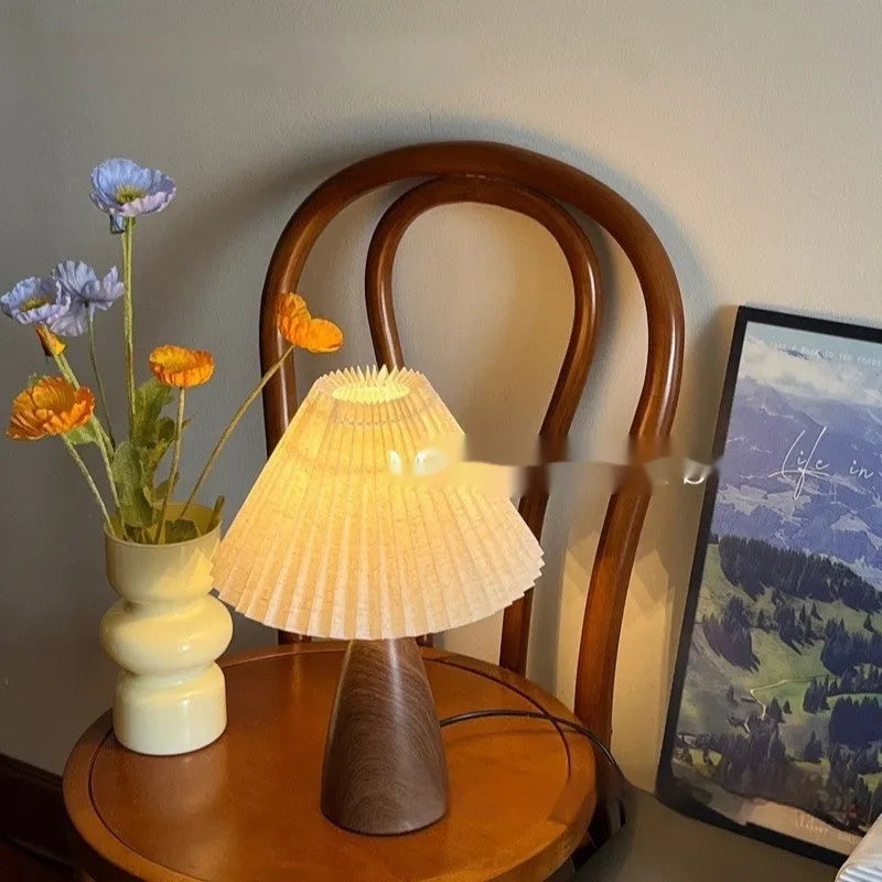 Nordic retro style ceramic table lamp with a tapered floral pleated shade and remote control on a wooden surface.