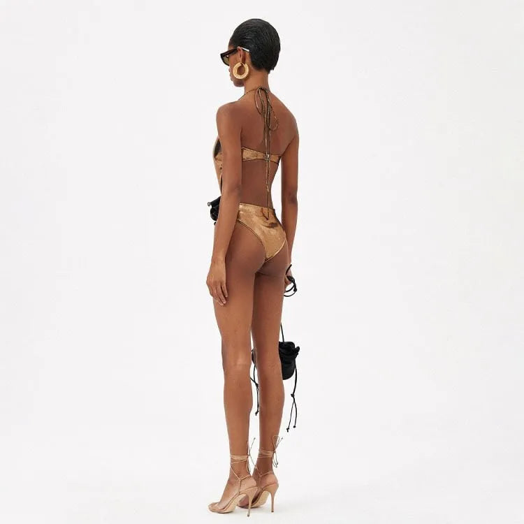 Gold handmade halter neck one-piece swimsuit with hollow-out detailing on a mannequin.