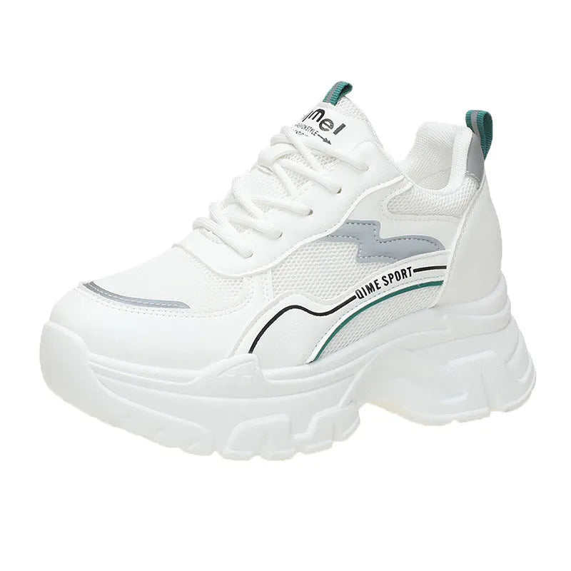 Women's white low-top sports trainers with cross shoulder straps and a lace-up front on a solid background.