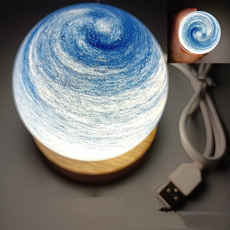 Modern planet-shaped USB night light with dimming on a desk.