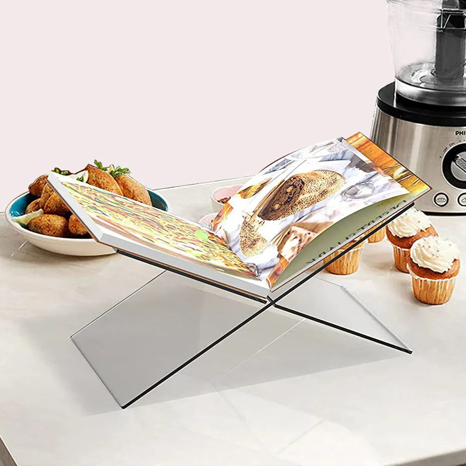 Clear acrylic X-shaped book display rack on desktop with books
