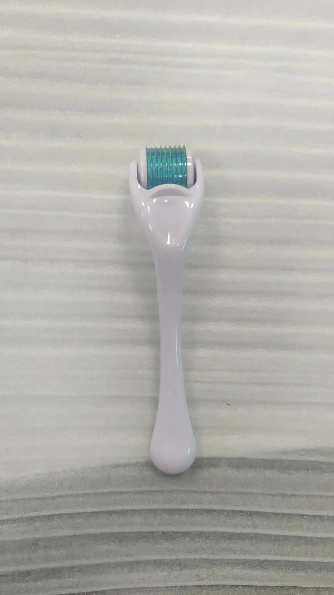 540 micro needle roller tool with black handle and coloured wheel on a white background.
