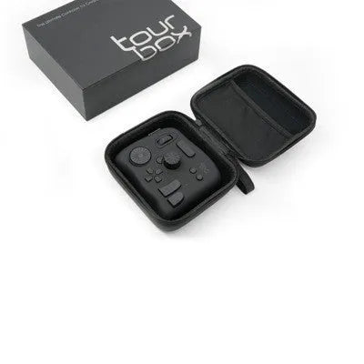 TourBox NEO black video editing controller with dials and buttons on a desk.