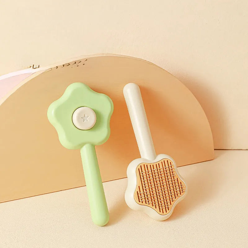 Green self-cleaning pet comb with stainless steel needles on a white background.