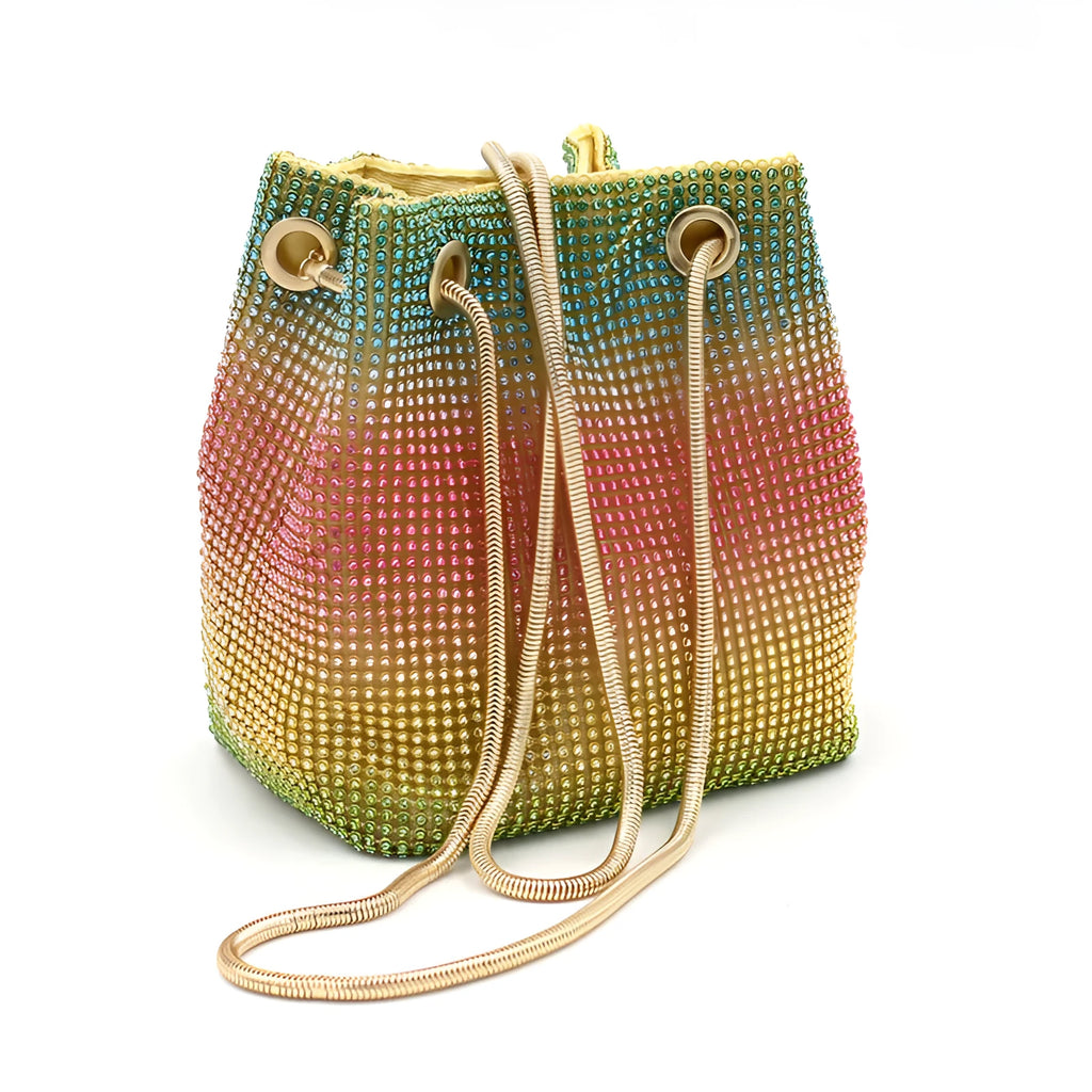 Soft rainbow rhinestone bucket handbag with adjustable long strap on a neutral background.
