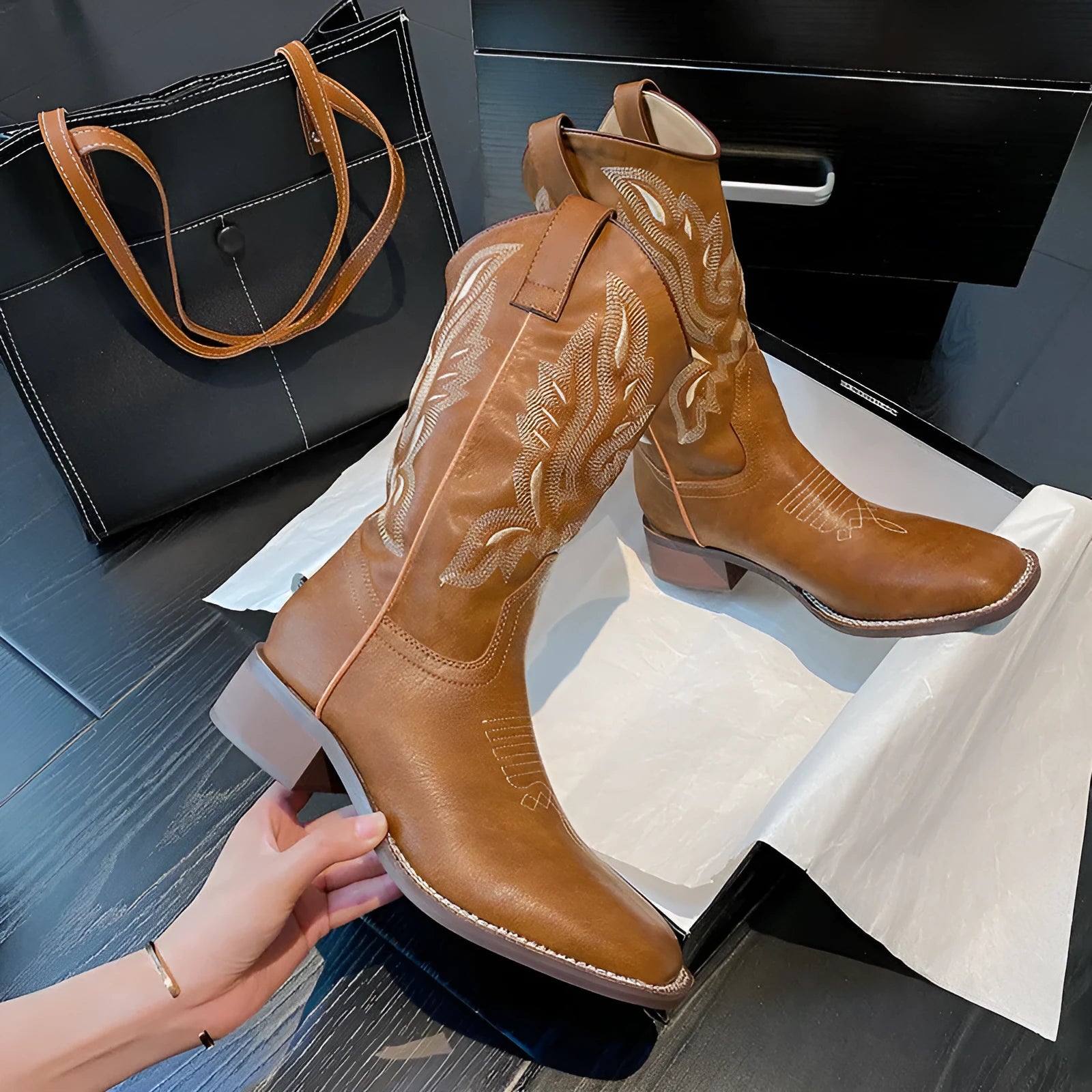 Brown women's mid-calf boots with embroidered pattern, round toe, and low square heel on a rubber sole.