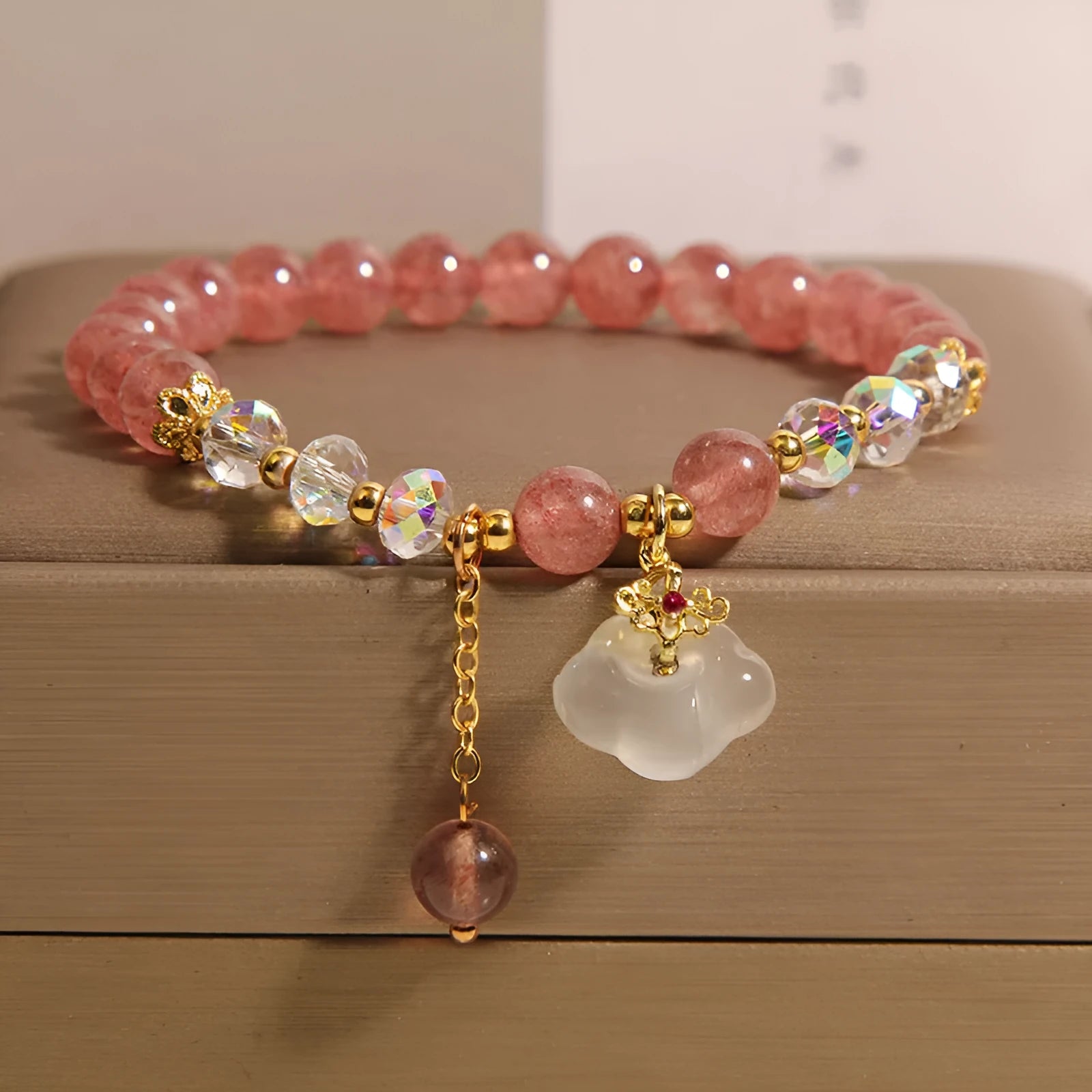 Women's adjustable crystal bracelet with strawberry quartz and white agate beads featuring auspicious cloud charm