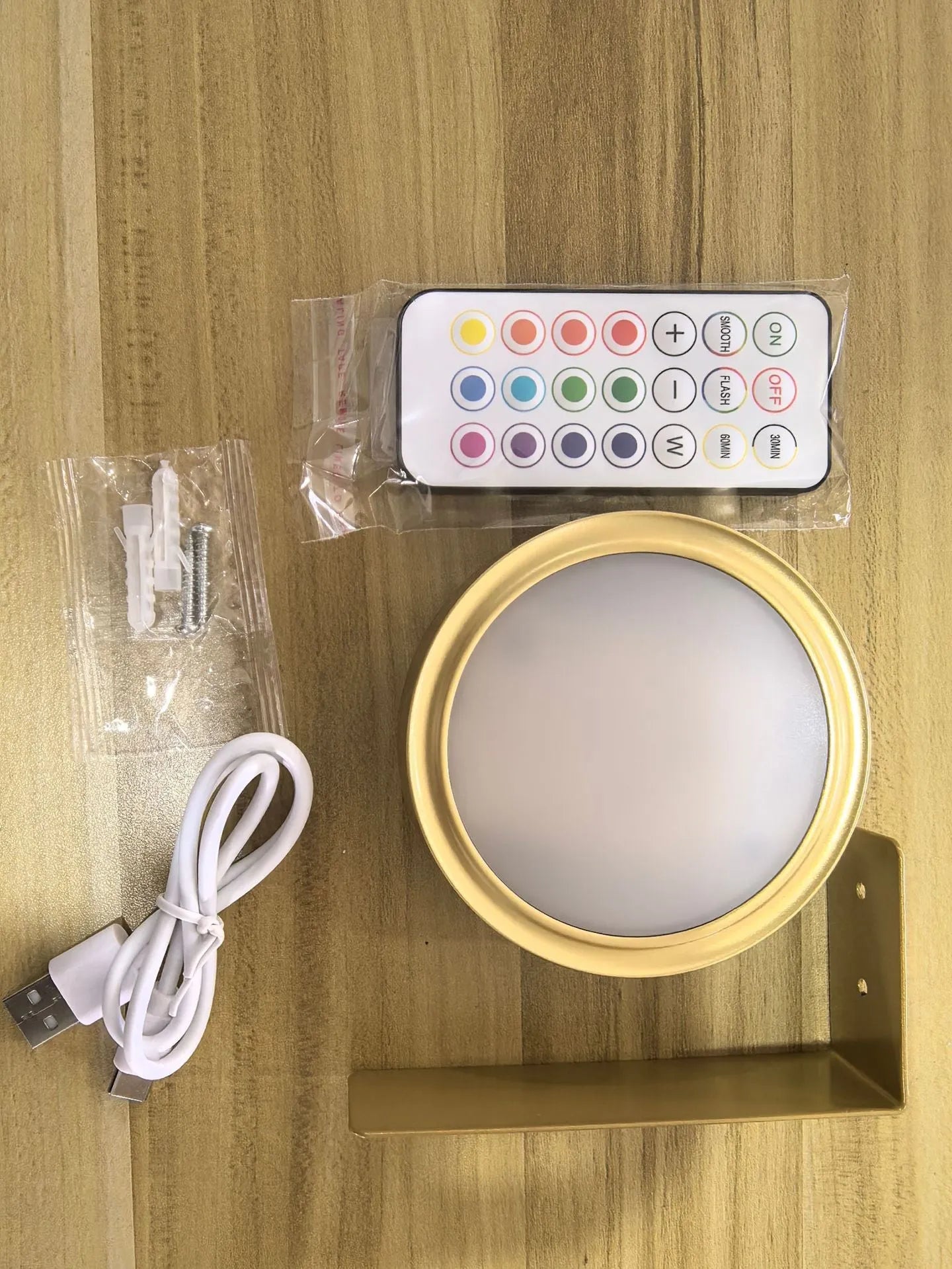 Black magnetic wireless LED lamp with remote control mounted next to a painting on a wall.