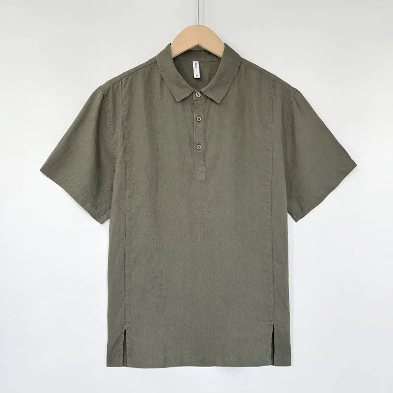 Man wearing a light grey green linen short-sleeve top with a V-neck and thin lapels, showcasing the loose fit.