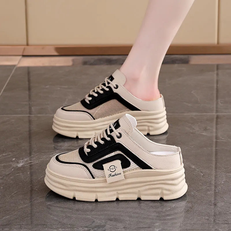 Women's black half slippers with mesh panels, round toe, and a rubber sole, shown on a light background.