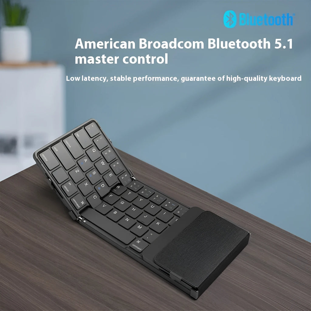 Black folding Bluetooth keyboard showing compact folded size beside mobile phone