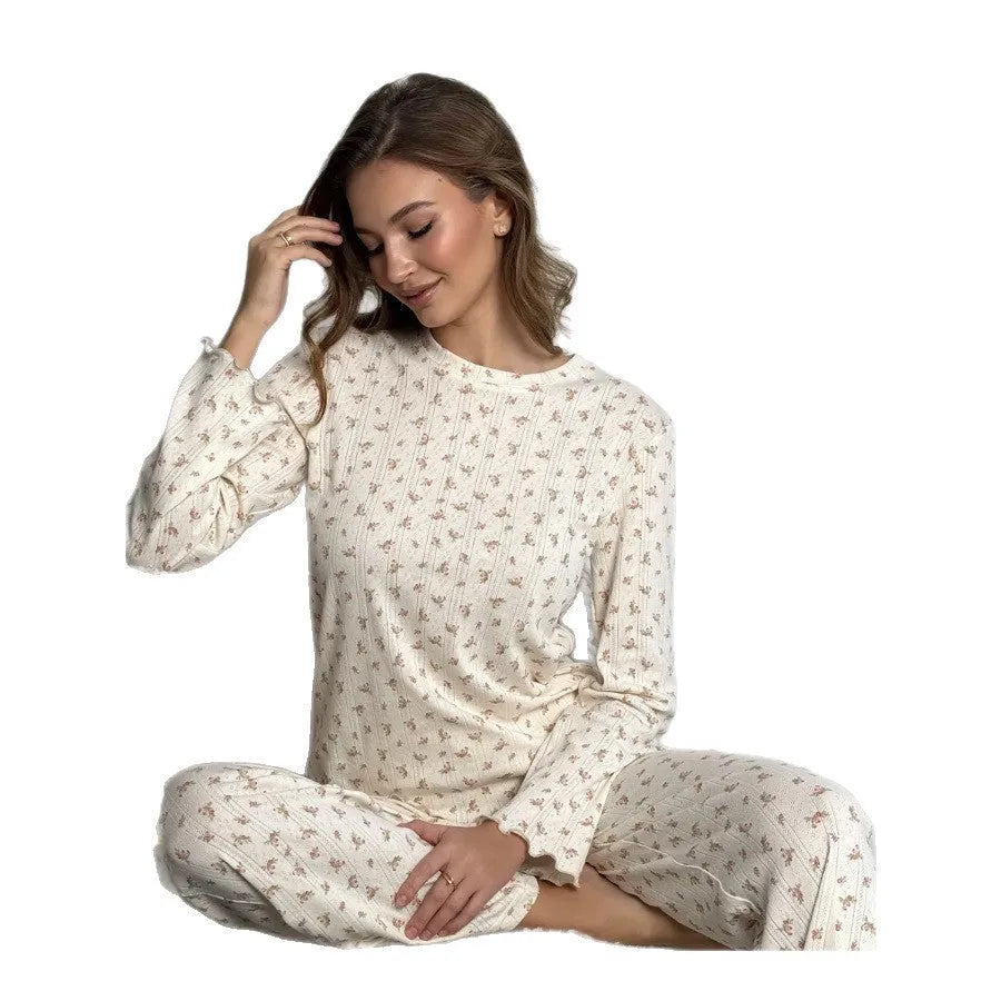 White women's floral print bell sleeve top and wide leg pants suit laid flat.