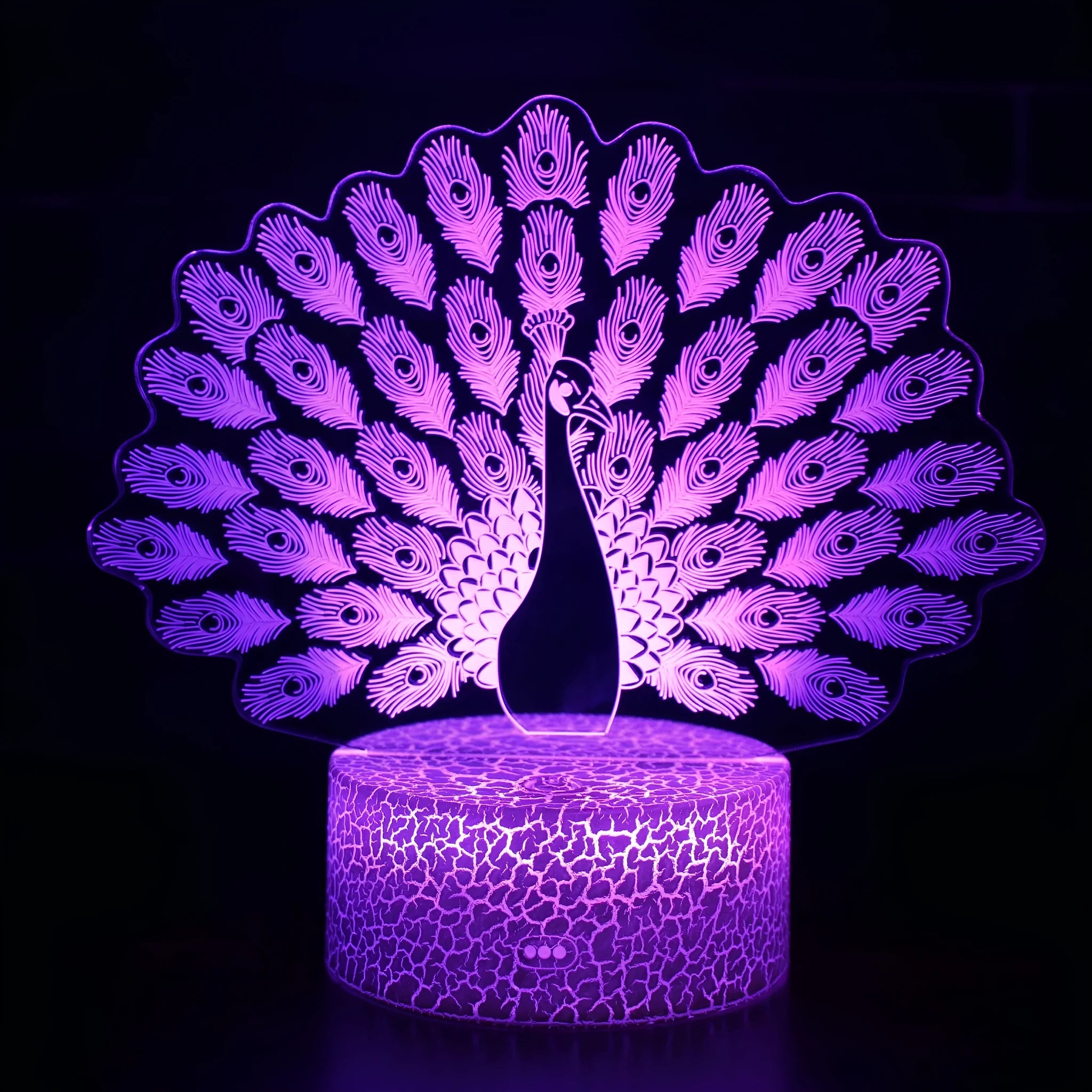 Small blue 3D acrylic USB table lamp with cracked base design lit up on a wooden desk.