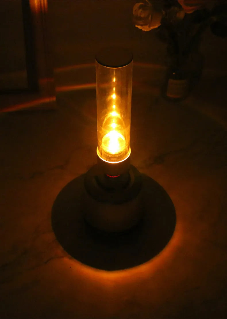 White silver cylindrical candlelight Bluetooth speaker and night light unit on a table