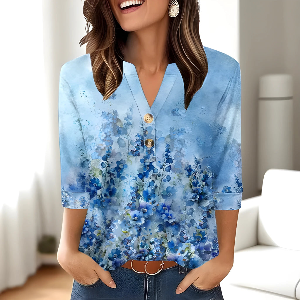 Women's loose grey V-neck t-shirt with a colourful 3D geometric pattern print on the front.