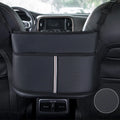 Black leather car seat organiser bag with carbon fibre pattern, shown in a car's centre seat gap.
