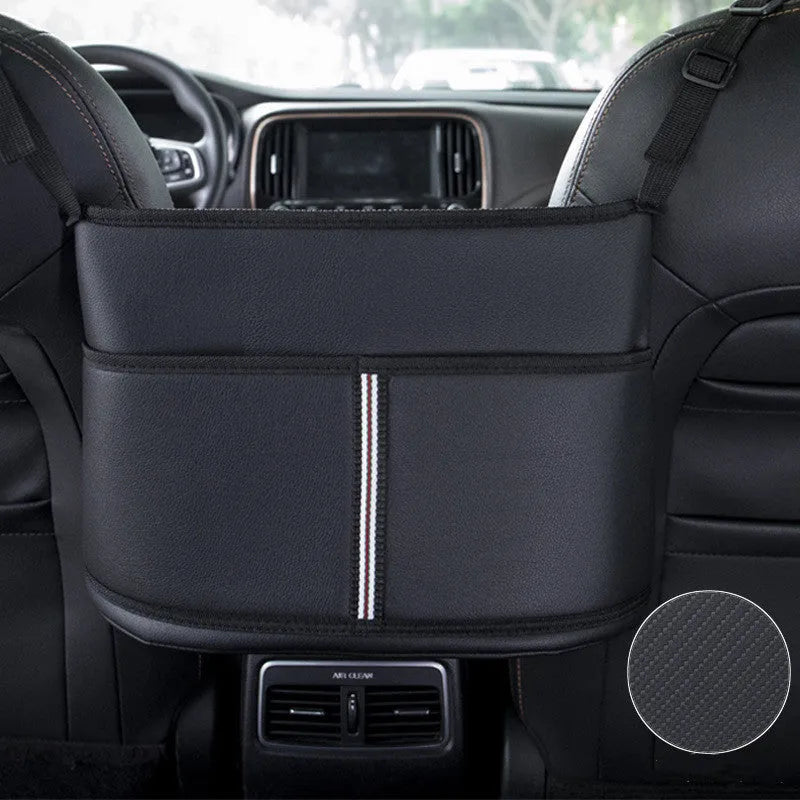 Black leather car seat organiser bag with carbon fibre pattern, shown in a car's centre seat gap.