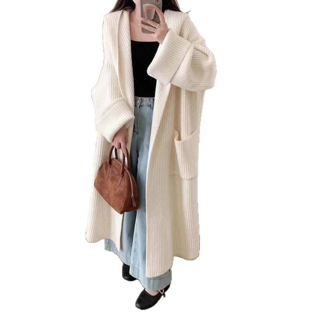 A woman wearing a loose, milky white hooded cardigan coat with raglan sleeves.