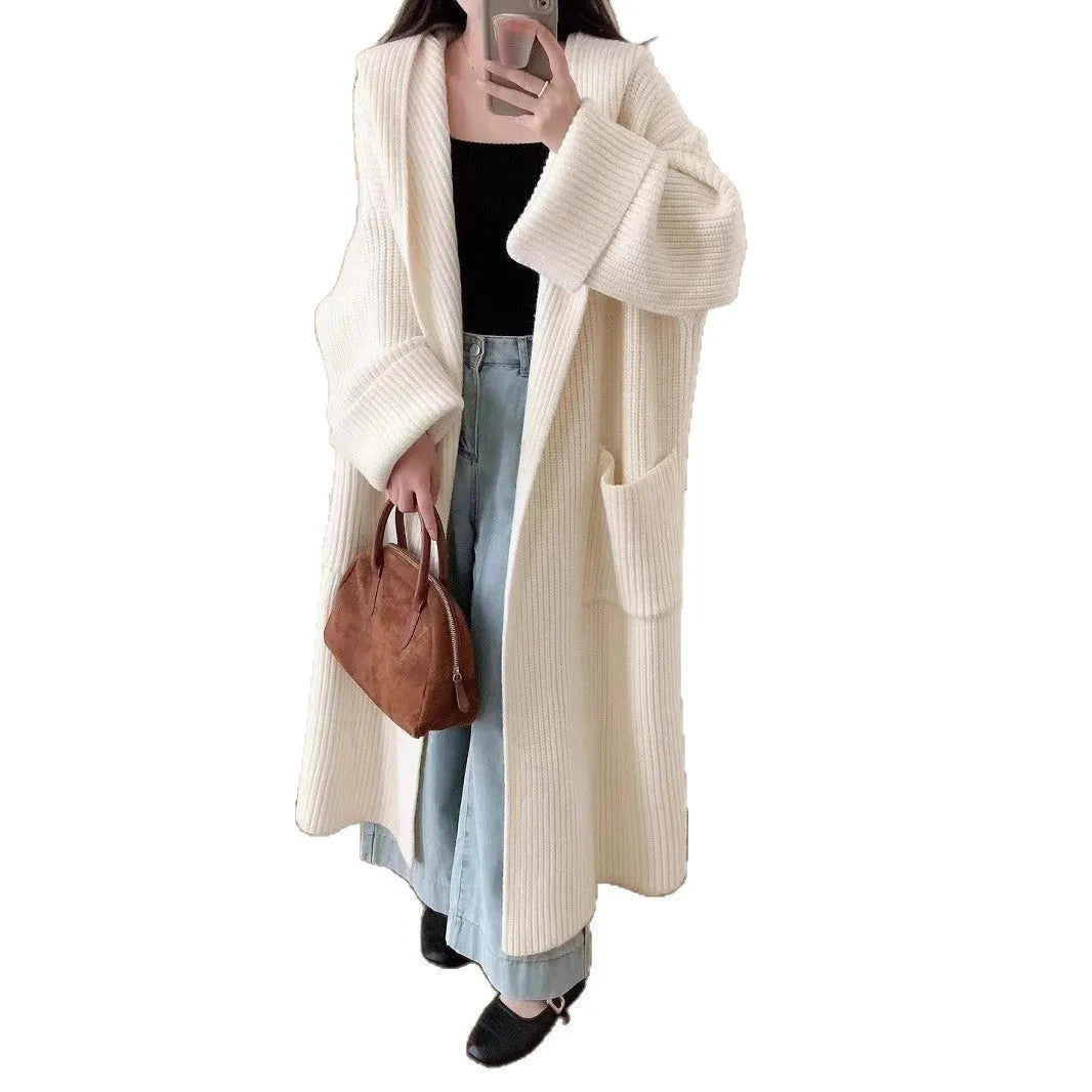 A woman wearing a loose, milky white hooded cardigan coat with raglan sleeves.