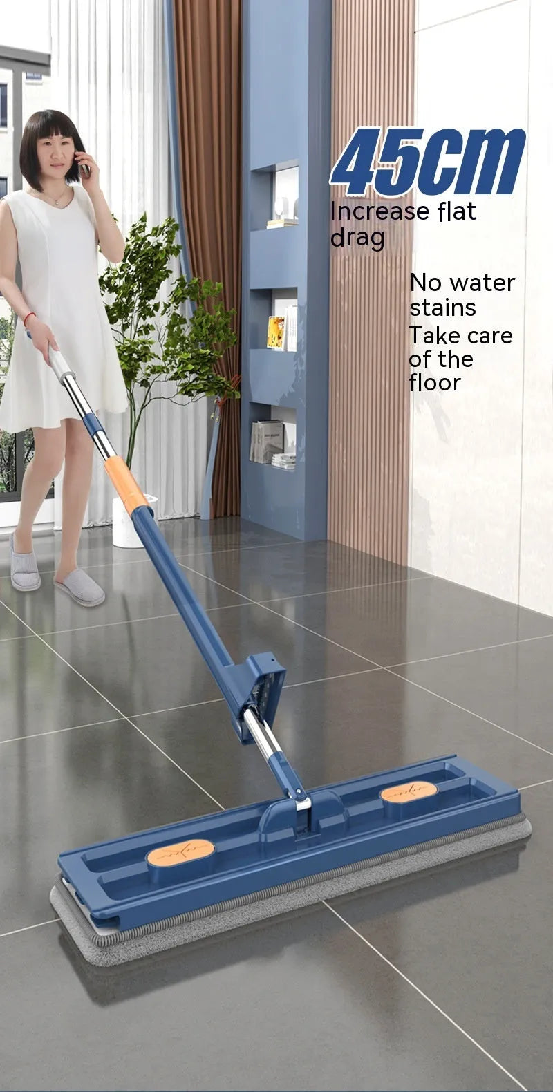 Large blue flat mop with a long stainless steel handle and a rotating head on a wooden floor.
