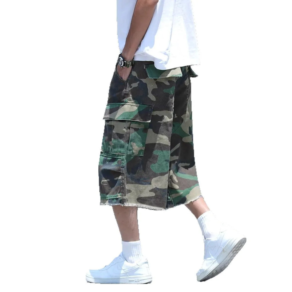 Man wearing loose, cropped camouflage shorts in a khaki colourway, showcasing the summer workwear style.