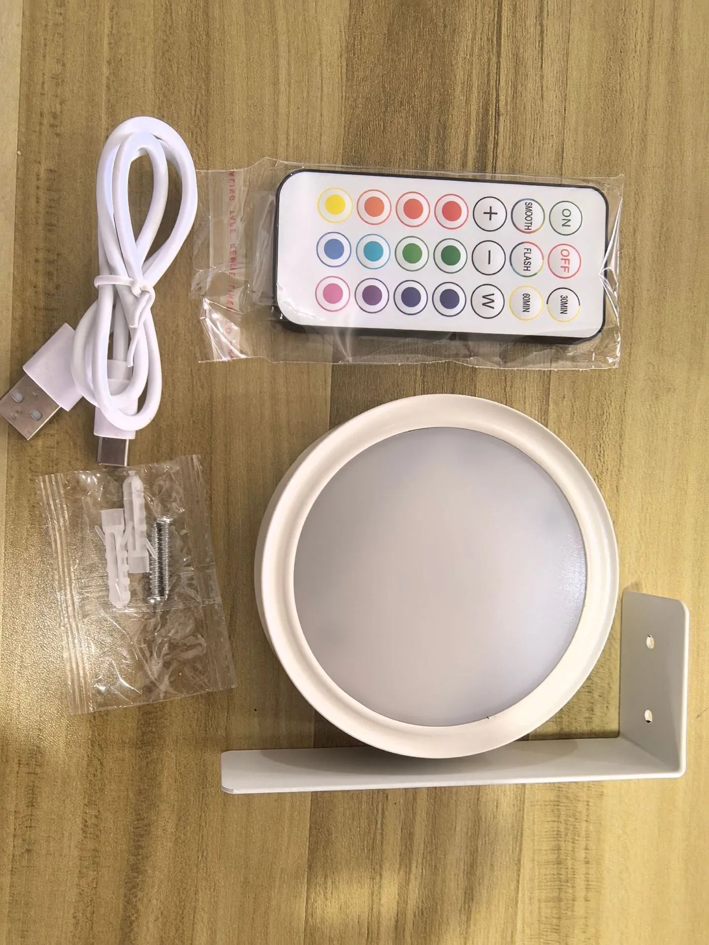 Black magnetic wireless LED lamp with remote control mounted next to a painting on a wall.
