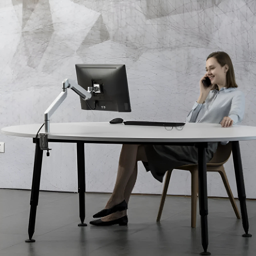 Silver aluminium laptop stand with an adjustable air-pressure arm holding a notebook
