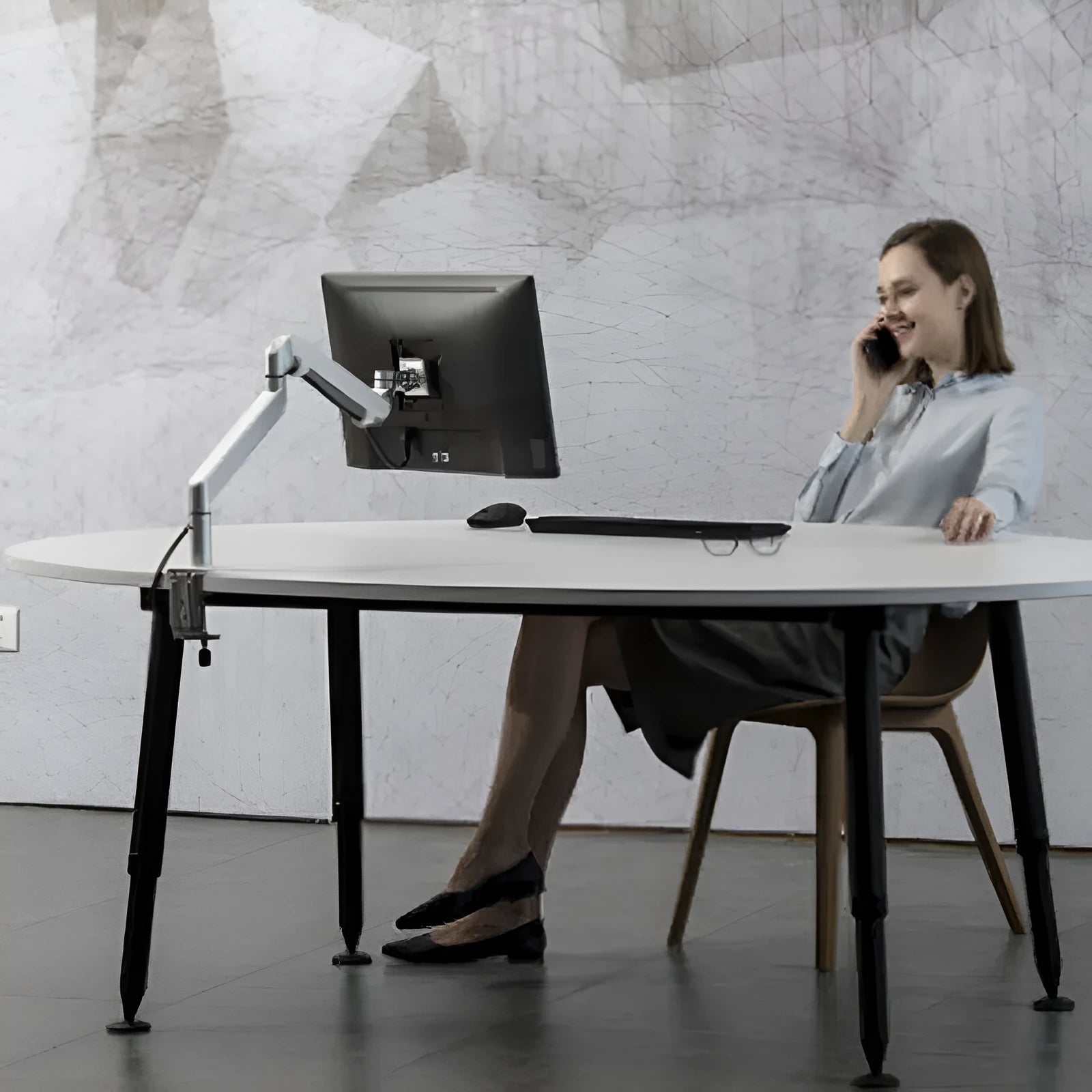 Silver aluminium laptop stand with an adjustable air-pressure arm holding a notebook