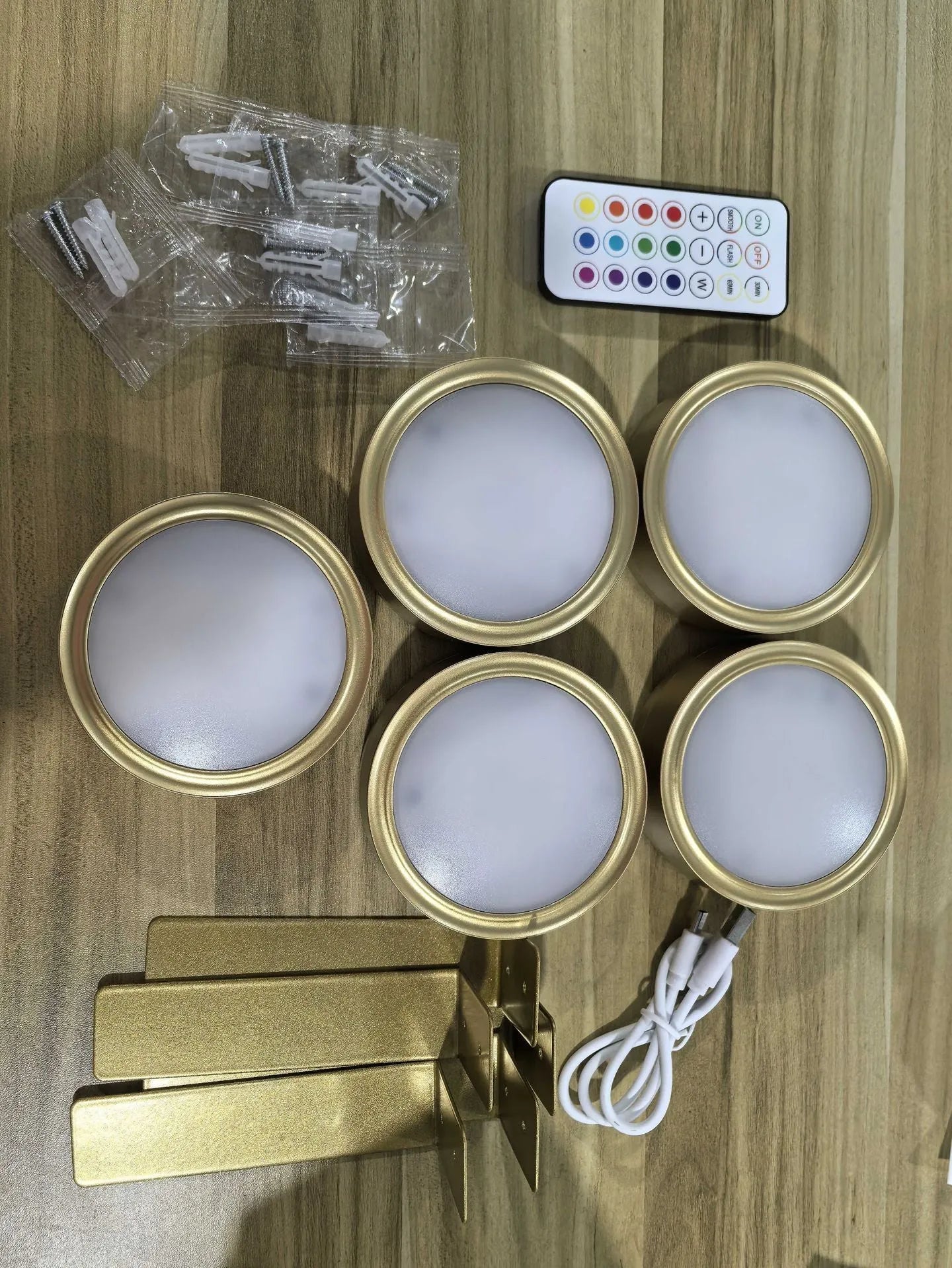 Black magnetic wireless LED lamp with remote control mounted next to a painting on a wall.
