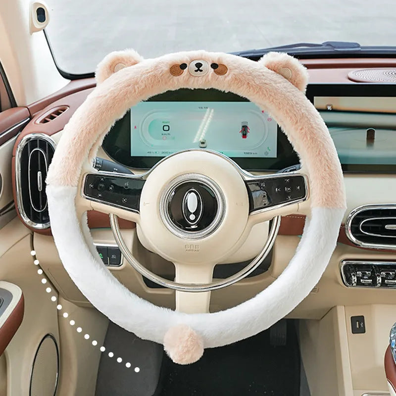 Plush steering wheel cover with embroidered bear design, shown fitted on a car steering wheel.