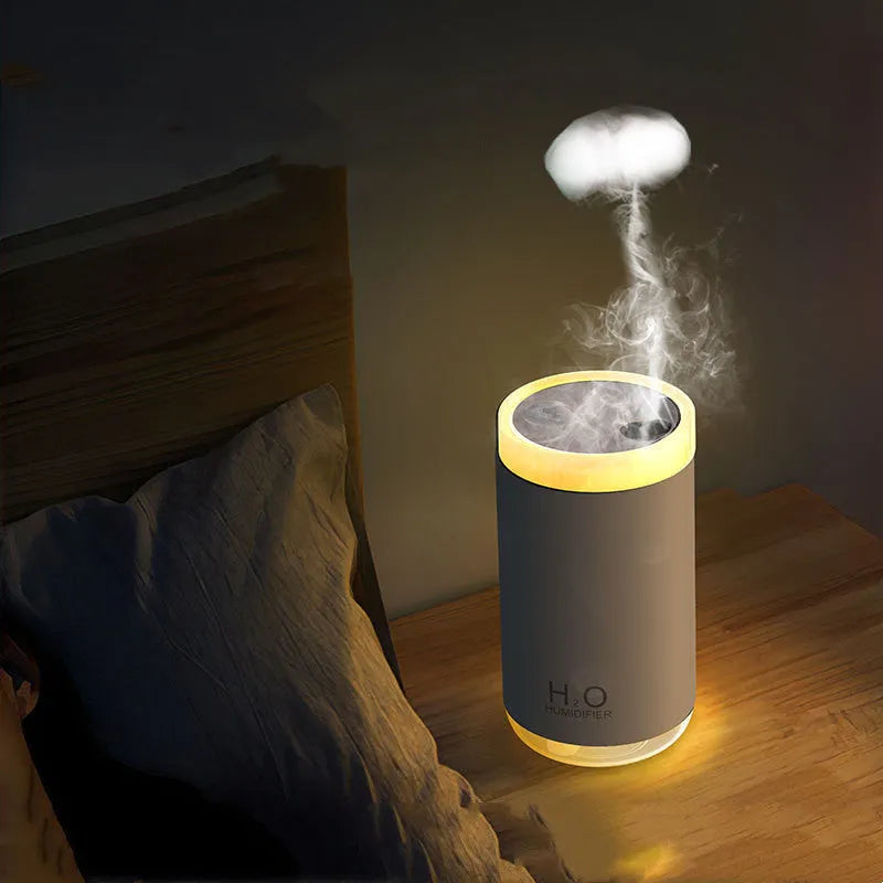White jellyfish-shaped USB humidifier with warm night light on wooden surface