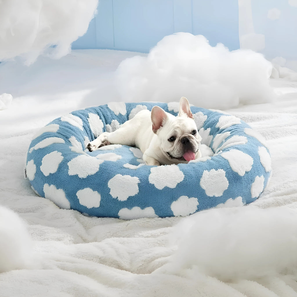 Round blue and white plaid dog bed with a plastic base on a wooden floor.