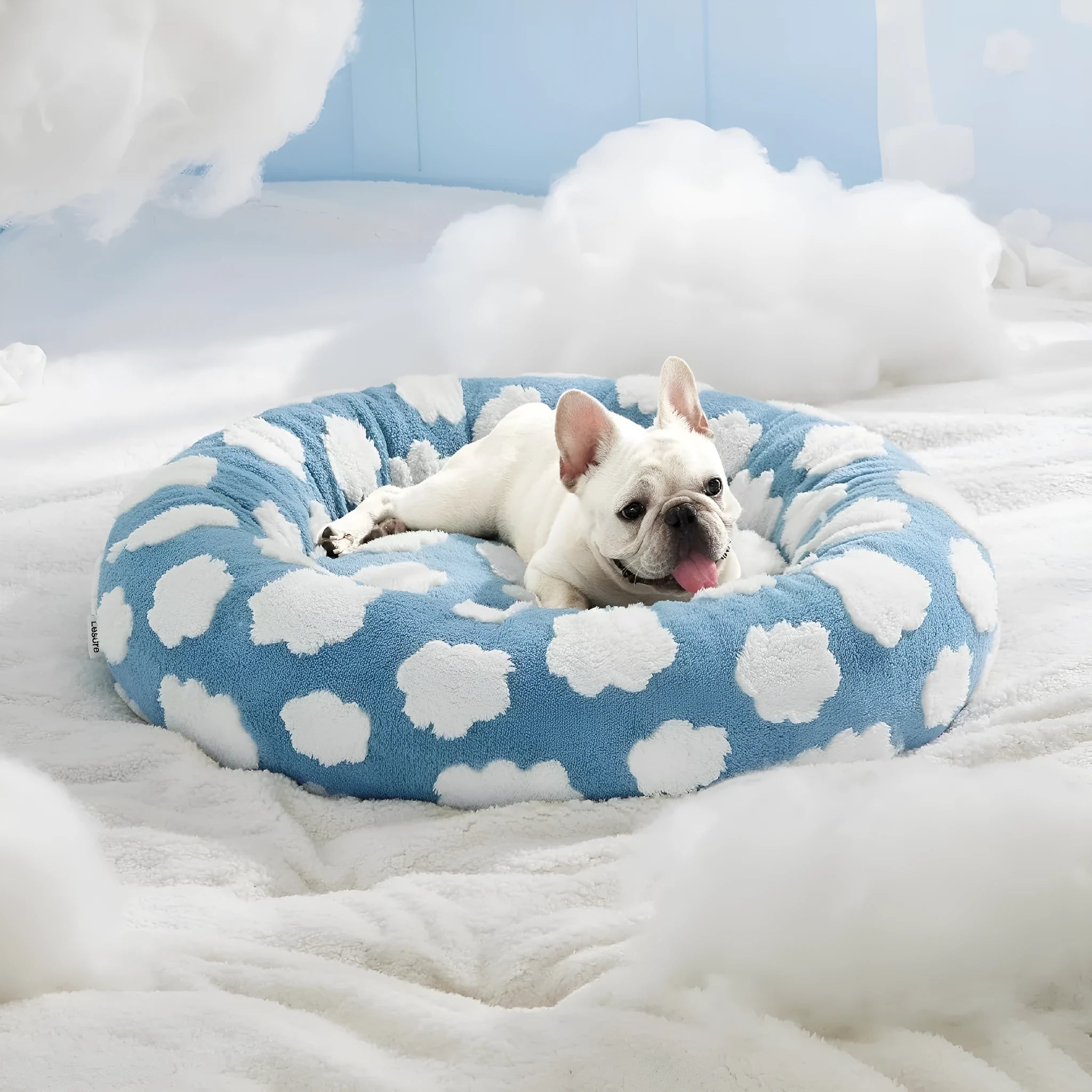 Round blue and white plaid dog bed with a plastic base on a wooden floor.