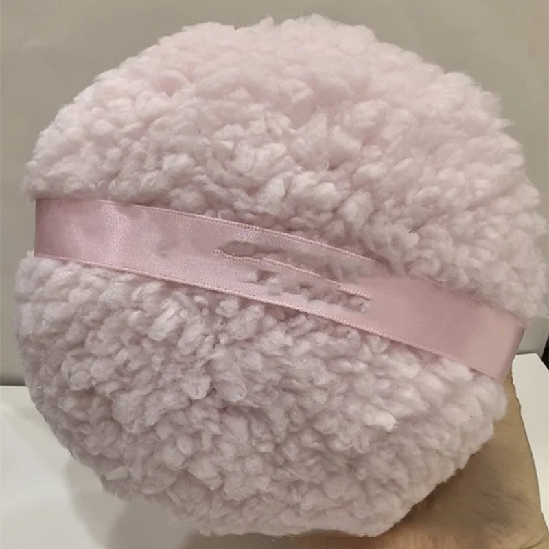 Large rectangular plush powder puff for makeup application in pink, white, or skin colour.