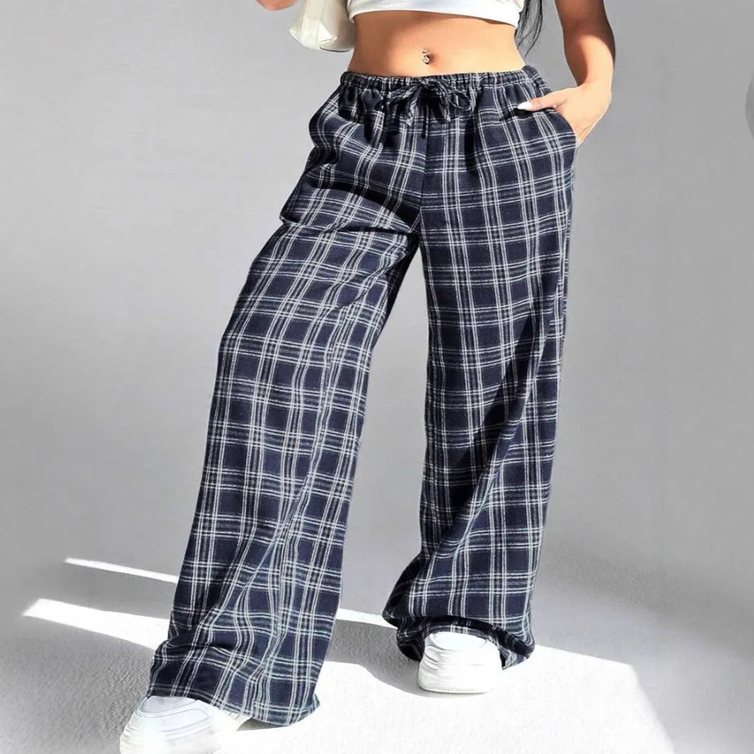 Red plaid women's casual trousers with a drawstring waist and pockets on a hanger.