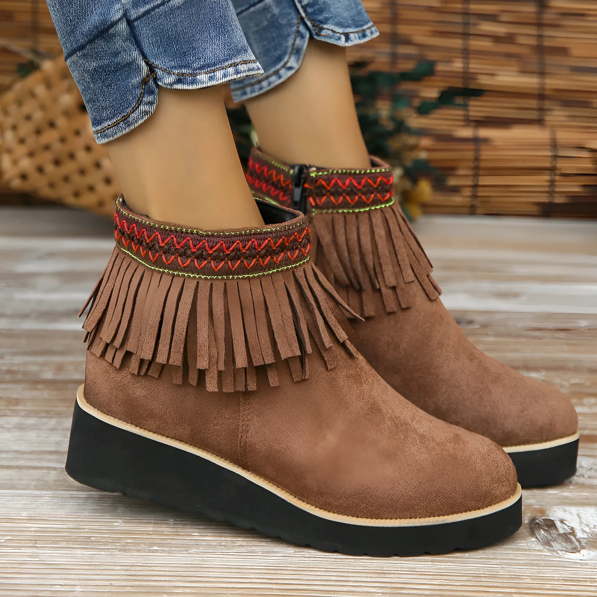 Women's suede wedge ankle boot with tassel detail, side zip, and a thick rubber sole.