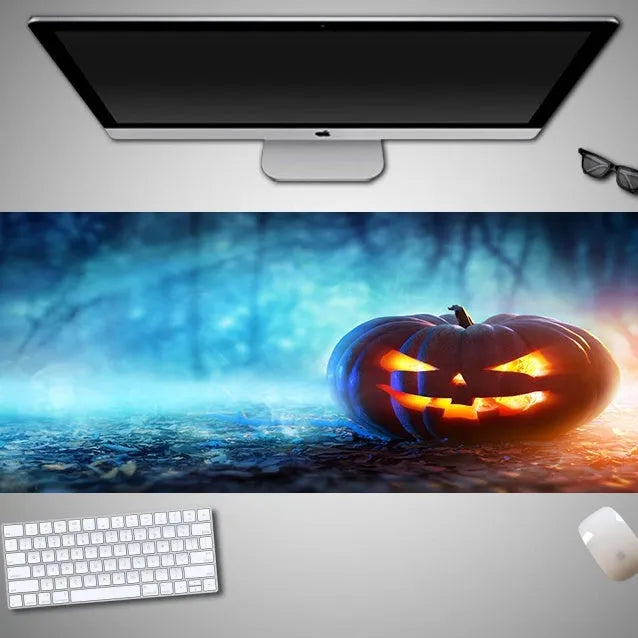Large Halloween patterned gaming mouse pad on a desk showing non-slip rubber base and extra-long design.