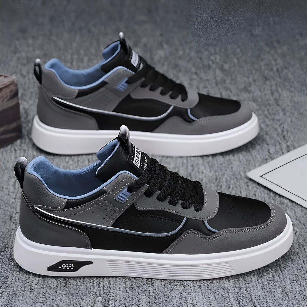Men's low-top beige canvas board shoes with leather stitching details on a white background.