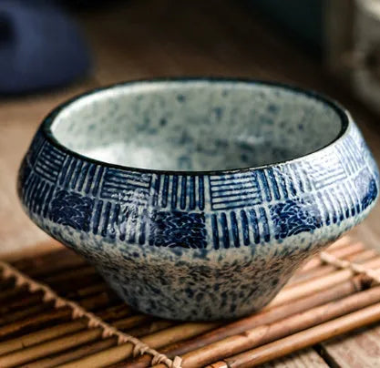 Tall porcelain ceramic Japanese soup bowl with underglaze vintage pattern on wooden table.