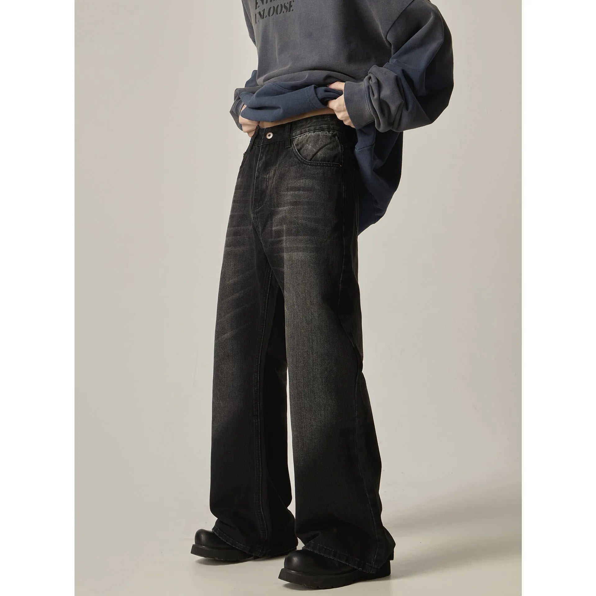Black loose straight-leg jeans with a retro light wash and zip fly closure laid flat.