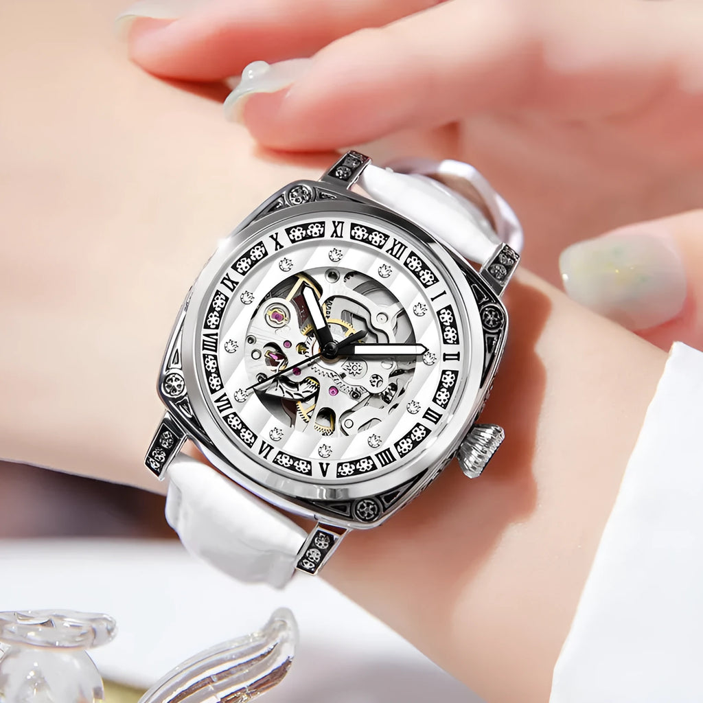 Men's black leather strap mechanical watch with luminous hands on a wrist.