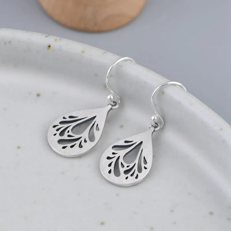 925 sterling silver hollow water drop retro earrings for women, showing grinding texture.